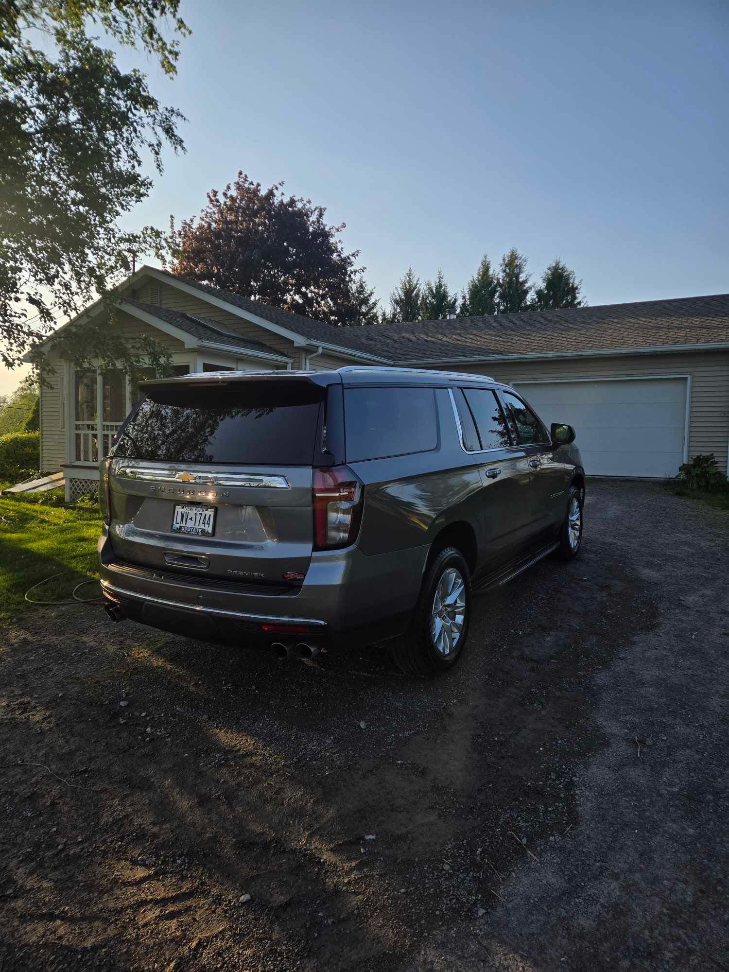 Chevrolet Suburban Premier detailed and parked in the driveway at sunset